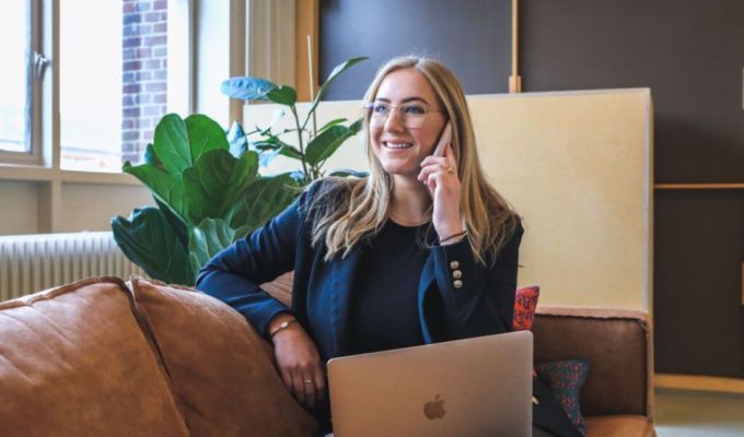 Obrazek dekoracyjny: Pani siedzi na kanapie, rozmawia przez telefon