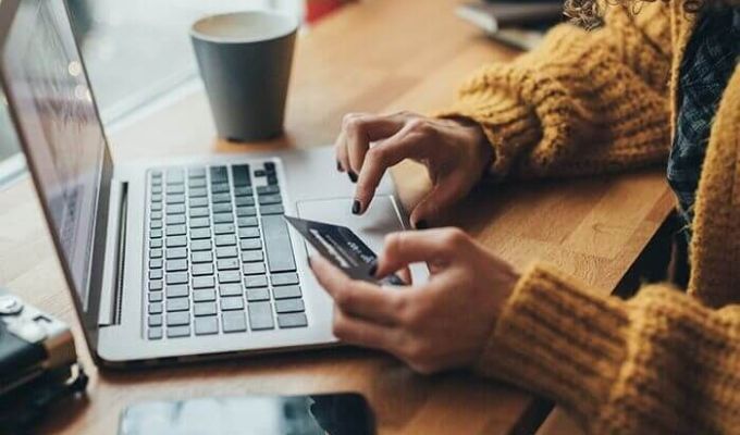 Pani przepisuje coś z karty do laptopa